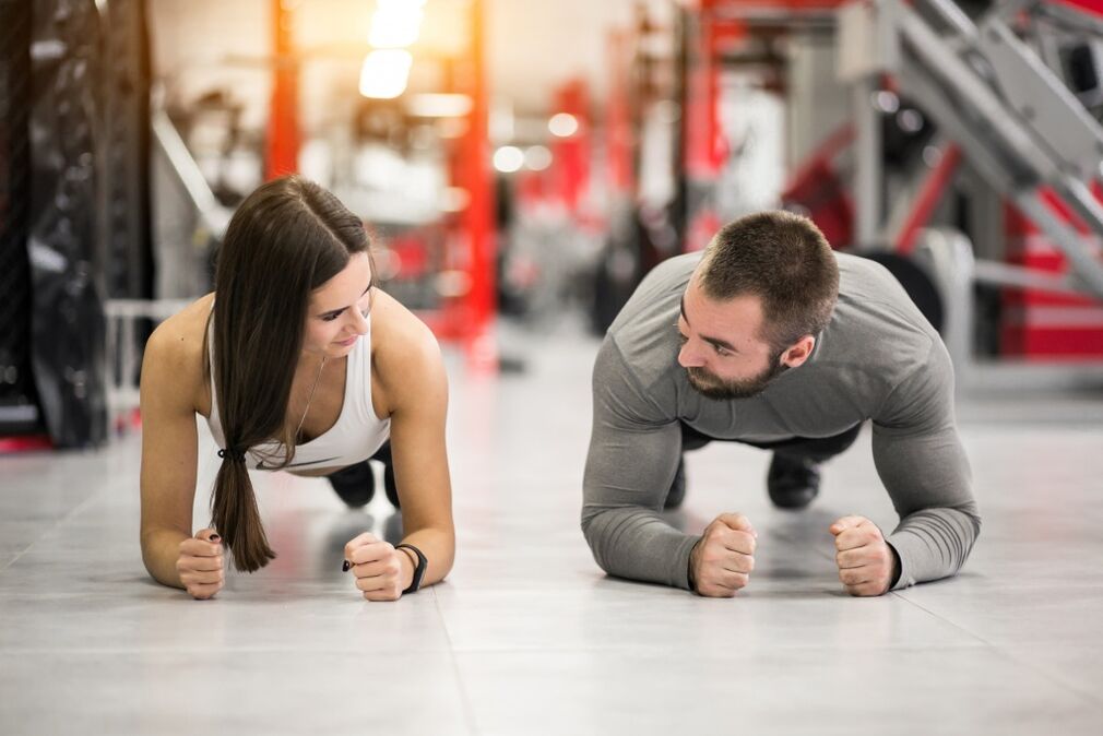 Seorang lelaki dan wanita melakukan senaman papan yang direka untuk semua kumpulan otot